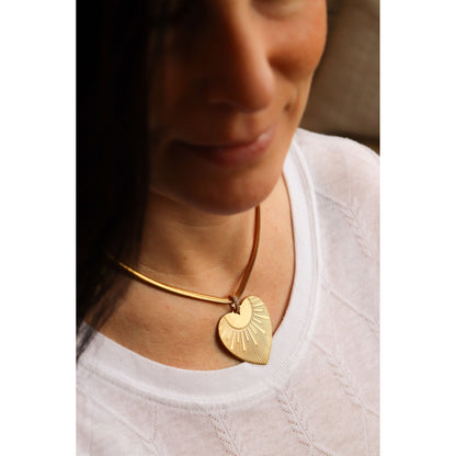 details of brass heart necklace being worn