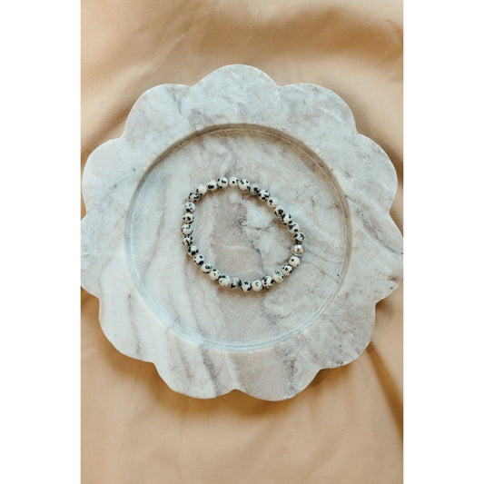 Bracelet on a marble coaster with a beige background