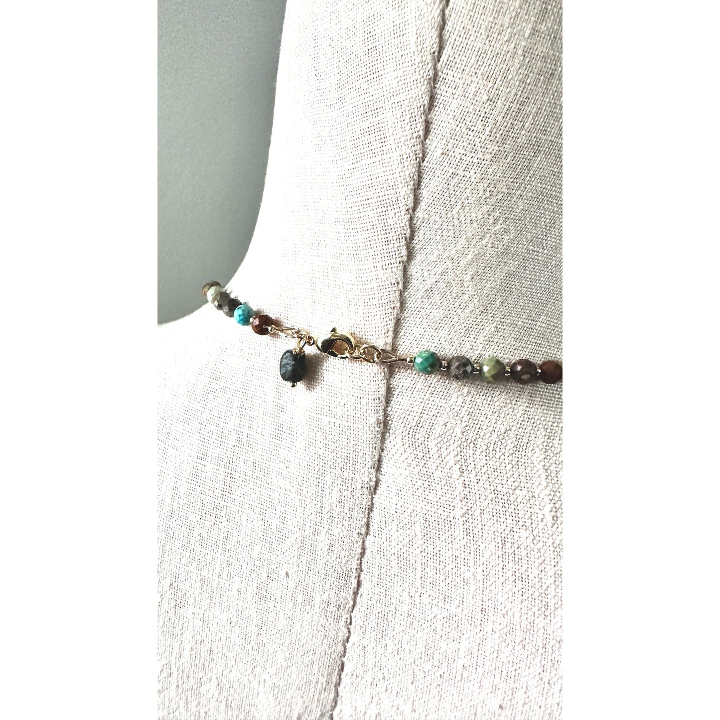 Necklace with turquoise beads on a white fabric background