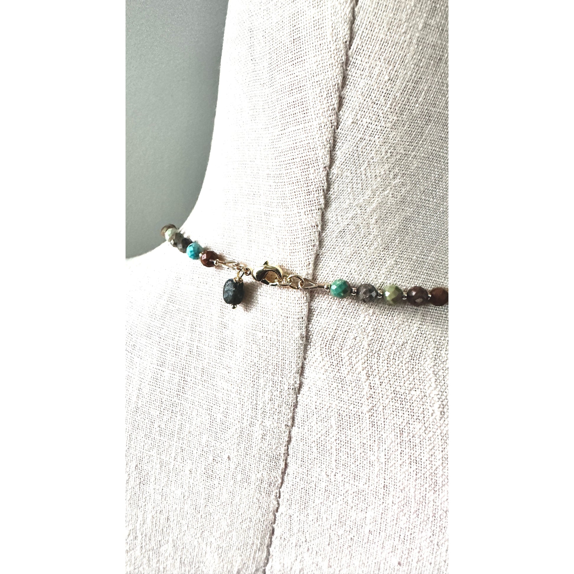 Necklace with turquoise beads on a white fabric background