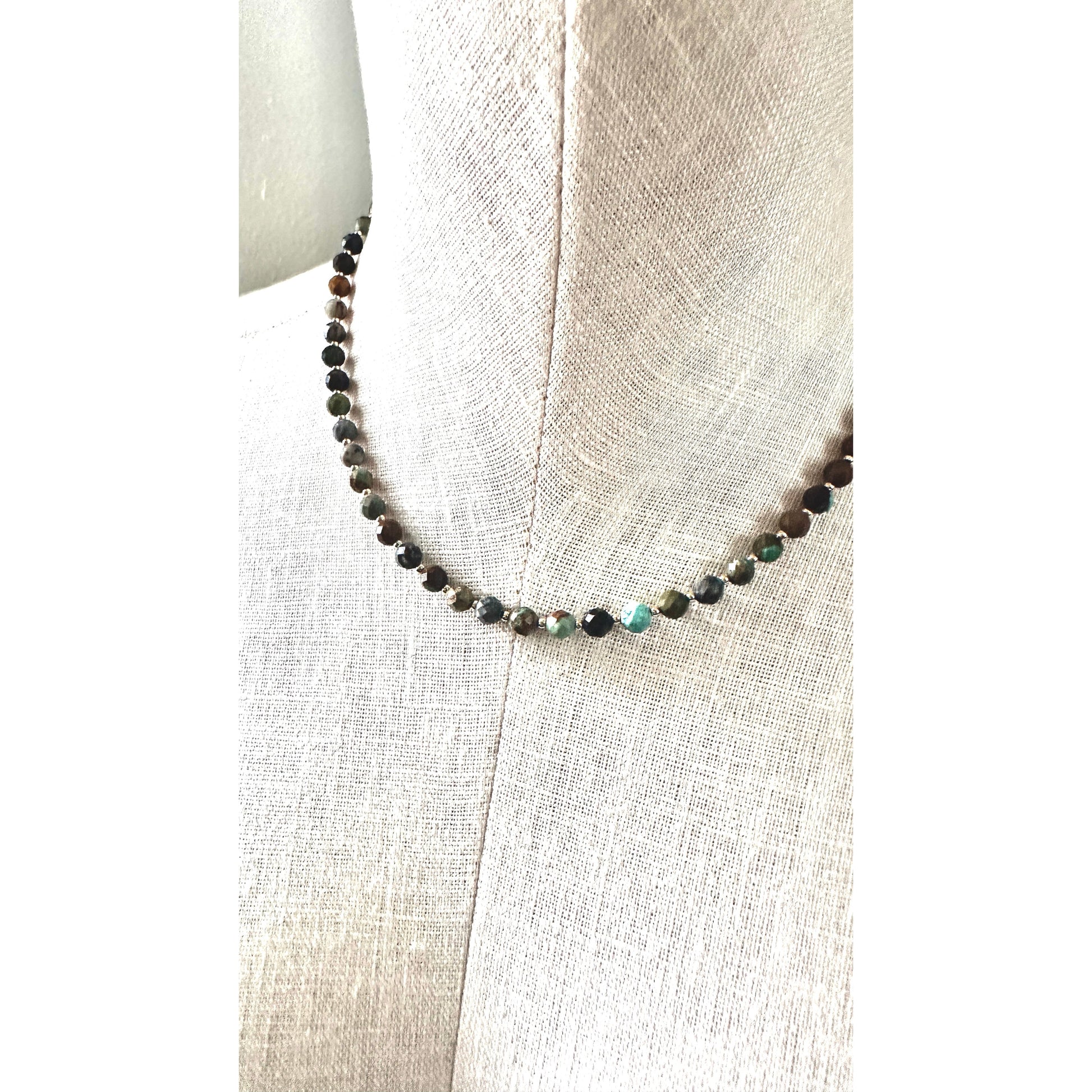 Beaded necklace on a mannequin with a neutral background