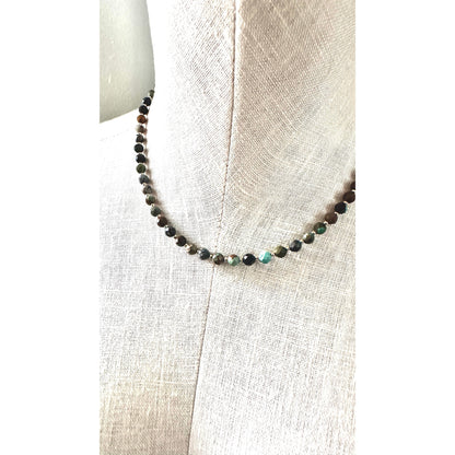 Beaded necklace on a mannequin with a neutral background