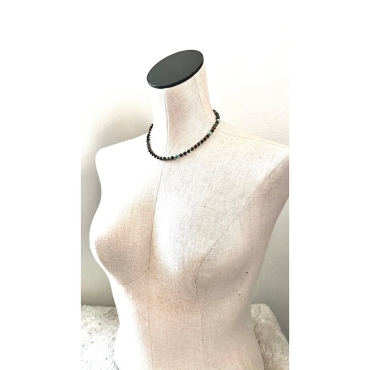 Mannequin wearing a black beaded necklace on a white background