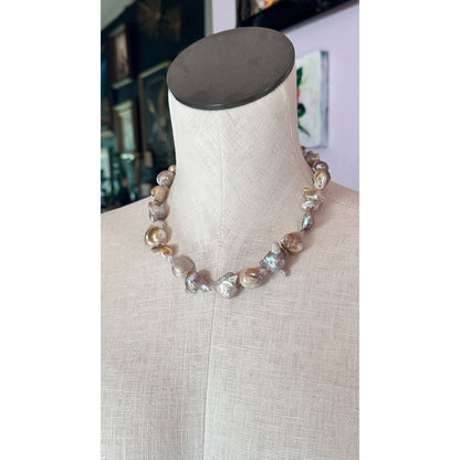 Necklace with large beads on a mannequin bust against a blurred indoor background