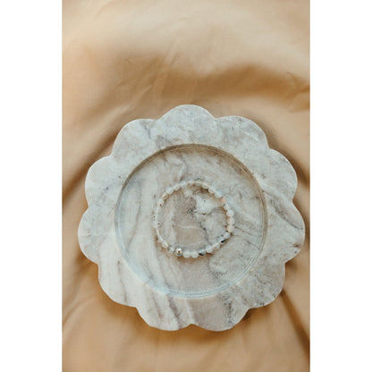 Decorative stone bowl with scalloped edge on a beige background
