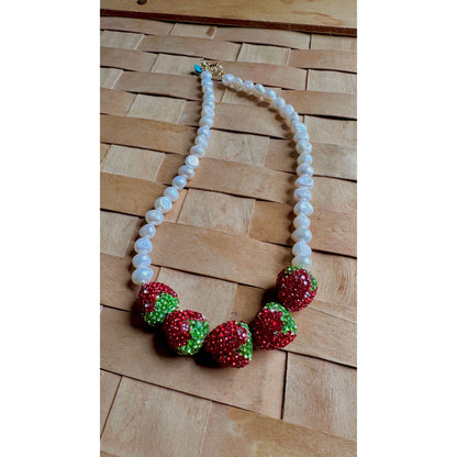 Necklace with strawberry-shaped beads on a wooden surface