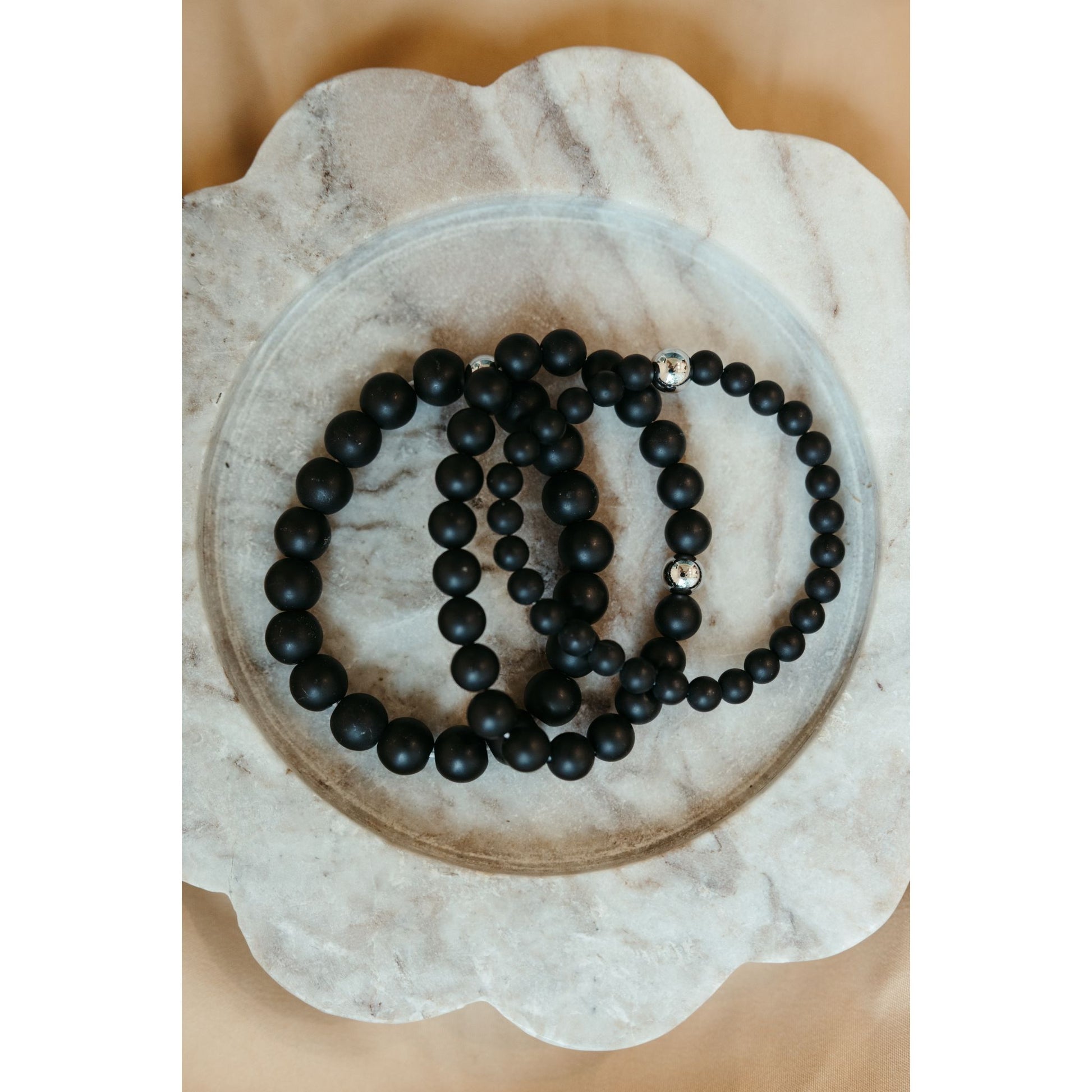 Black beaded necklace on a decorative stone plate