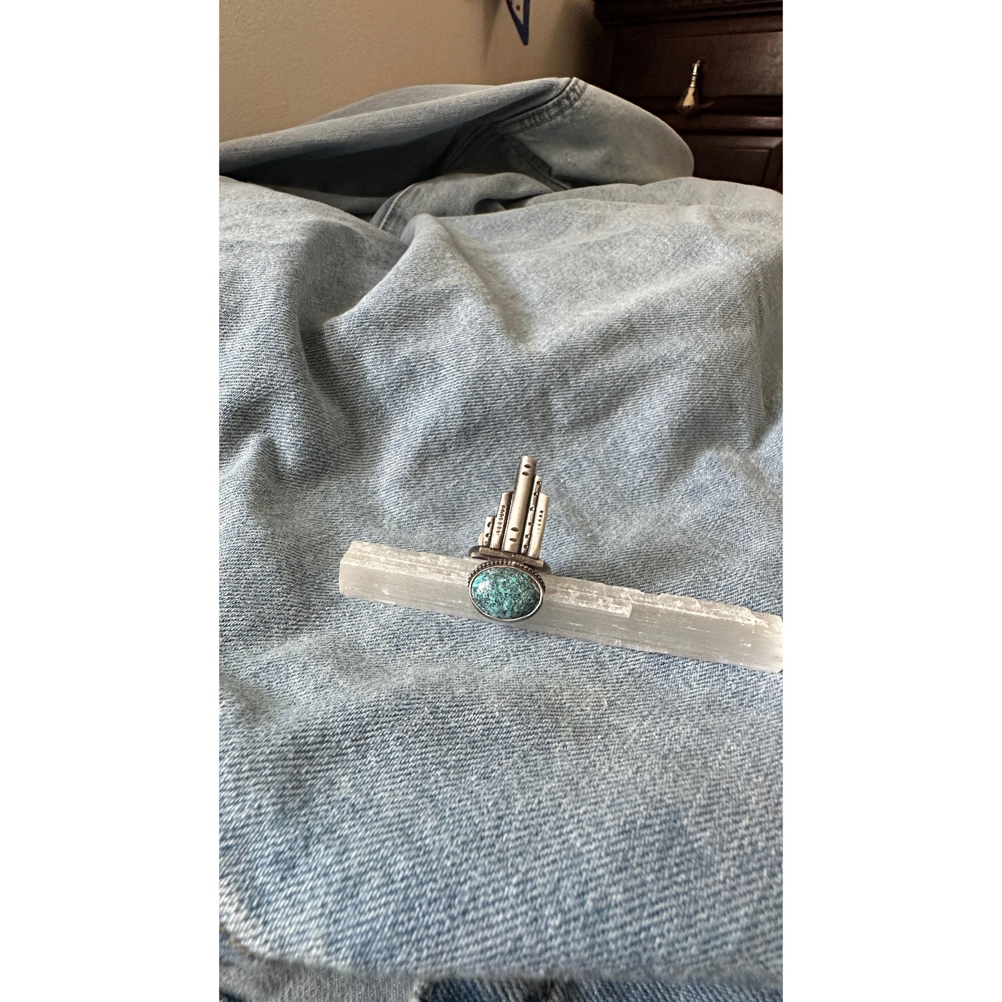 Silver and turquoise ring on denim fabric