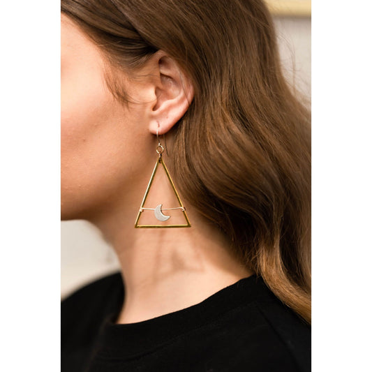Gold triangle-shaped earring worn by a person with brown hair.